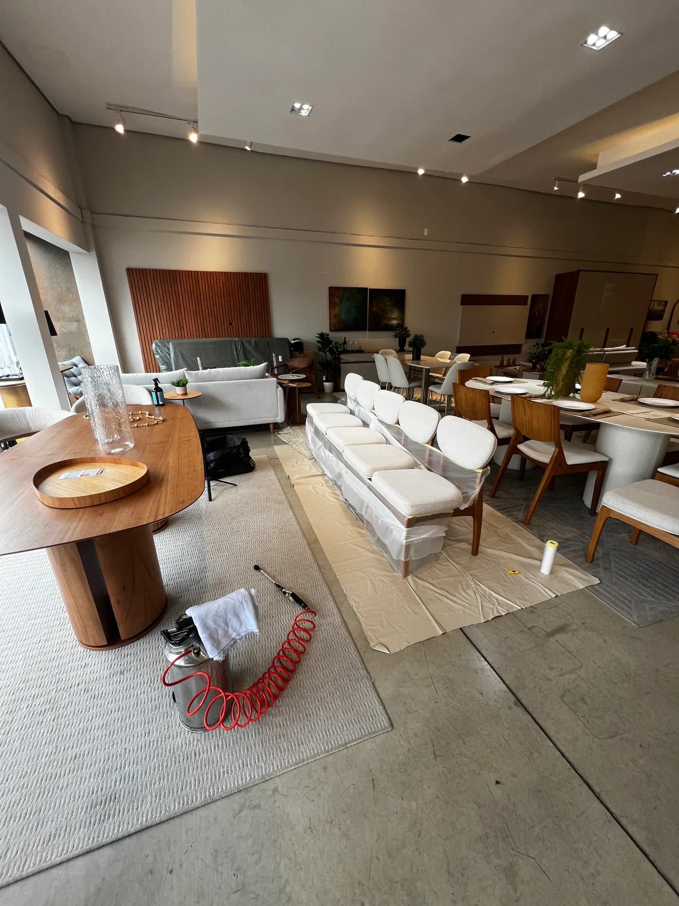 Showroom amplo de loja de móveis com sofás, mesas e cadeiras, e o equipamento de aplicação no chão